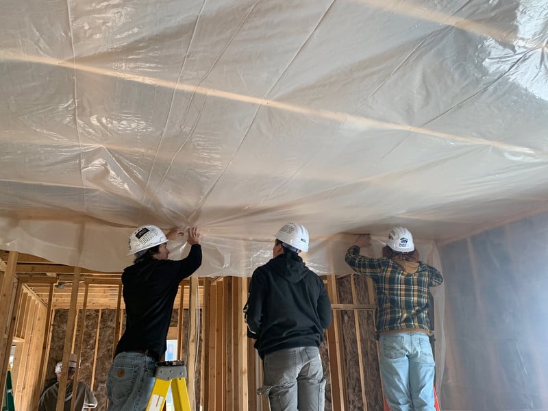 Senior Construction Tech 2 class insulating the ceiling and walls on a Habitat for Humanity house.