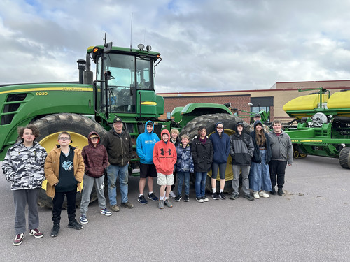 iLEAD students pose in front of a tractor brought to school by a local farmer.
