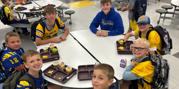Students with food sit in a circle.