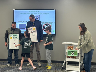 Students do a presentation with two adults showing of what are considered good or bad foods.