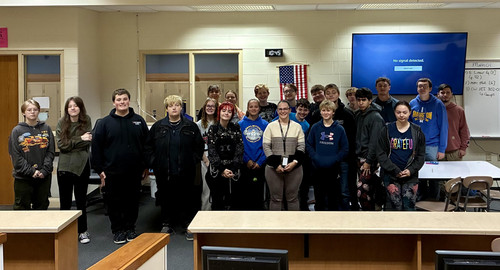 Students stand with Andrea Thompson after a presentation.