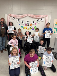 Students holding up custom caricature drawings during a classroom visit from 