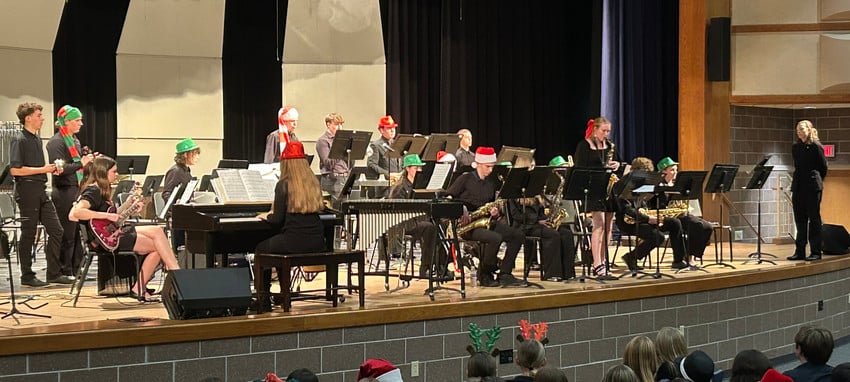 A student jazz band performs on a stage during a holiday concert.