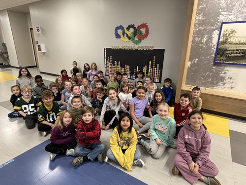 Students sit in a hallway below a 